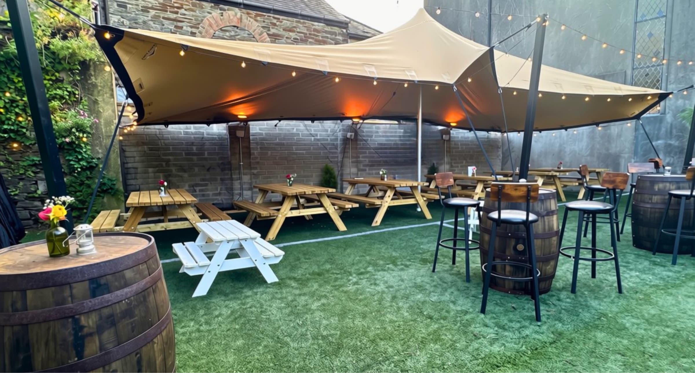 The courtyard by day, with its stretch tent and picnic benches